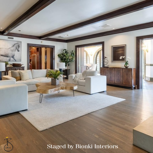 Luxury vacant home staging for a spacious living room featuring exposed beams and layered seating. Staged by Bionki Interiors. Luxury vacant home staging for a spacious living room featuring exposed beams and layered seating. Staged by Bionki Interiors.