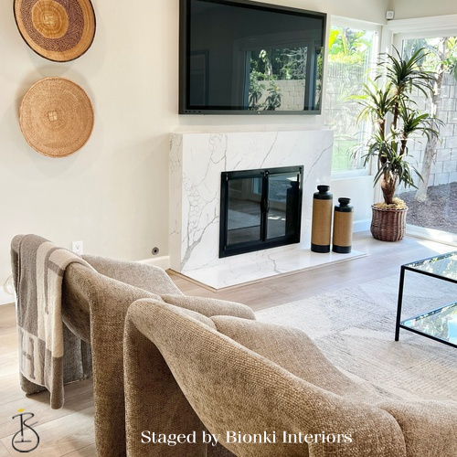 Luxury living room staging featuring a fireplace focal point and warm neutral tones designed for gathering. Staged by Bionki Interiors. Luxury living room staging featuring a fireplace focal point and warm neutral tones designed for gathering. Staged by Bionki Interiors.