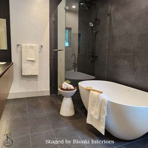 Luxury bathroom staging featuring a modern freestanding tub, oversized tile, and spa-inspired accessories designed to elevate the presentation. Staged by Bionki Interiors. Luxury bathroom staging featuring a modern freestanding tub, oversized tile, and spa-inspired accessories designed to elevate the presentation. Staged by Bionki Interiors.