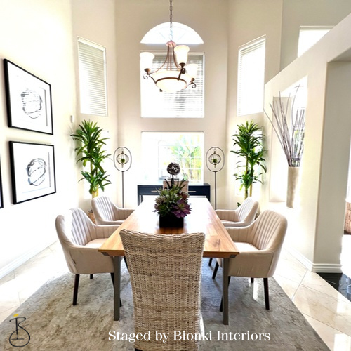 Luxury dining room staging in a light-filled space featuring an elongated table and upholstered seating. Staged by Bionki Interiors. Luxury dining room staging in a light-filled space featuring an elongated table and upholstered seating. Staged by Bionki Interiors.