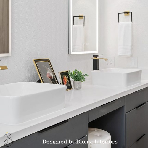 Custom bathroom vanity design featuring dual vessel sinks and warm metal accents. Designed by Bionki Interiors.