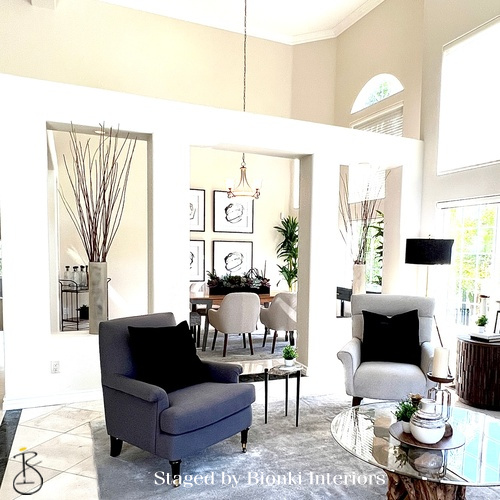 Luxury vacant home staging in a double-height living space filled with natural light, highlighting volume and architectural features. Staged by Bionki Interiors. Luxury vacant home staging in a double-height living space filled with natural light, highlighting volume and architectural features. Staged by Bionki Interiors.