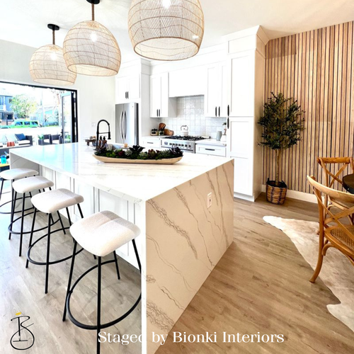 Luxury kitchen staging featuring a waterfall island, modern barstools, and warm wood accents designed to highlight functionality and buyer appeal. Staged by Bionki Interiors. Luxury kitchen staging featuring a waterfall island, modern barstools, and warm wood accents designed to highlight functionality and buyer appeal. Staged by Bionki Interiors.