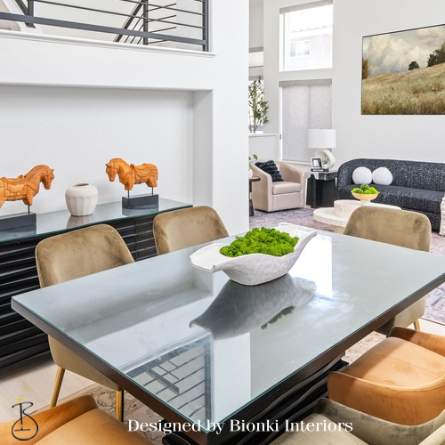 Custom open-concept dining and living design featuring a statement table and sculptural seating. Designed by Bionki Interiors.