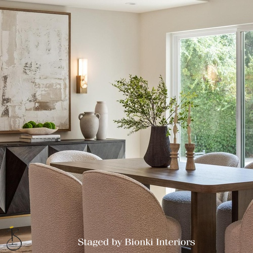Luxury dining room staging featuring a natural wood table and upholstered seating. Staged by Bionki Interiors. Luxury dining room staging featuring a natural wood table and upholstered seating. Staged by Bionki Interiors.