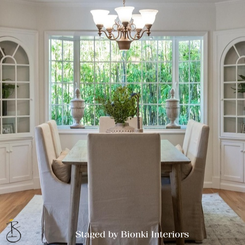 Luxury dining room staging featuring upholstered seating and garden-facing windows. Staged by Bionki Interiors. Luxury dining room staging featuring upholstered seating and garden-facing windows. Staged by Bionki Interiors.